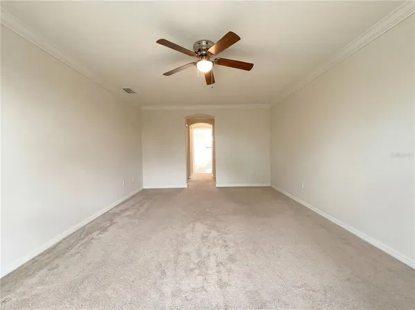 a view of an empty room with ceiling fan