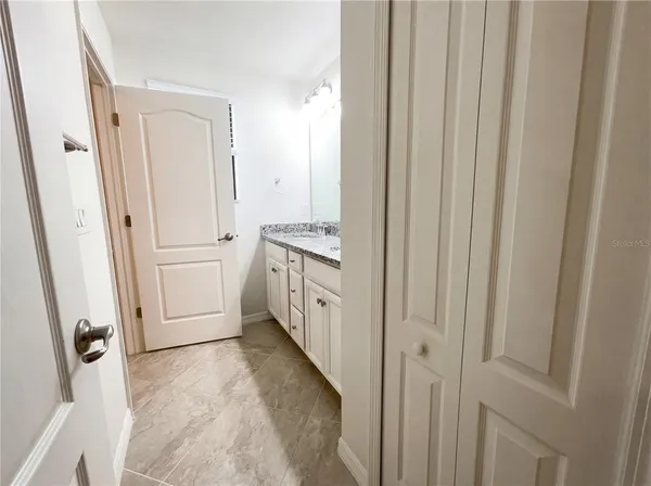a bathroom with a granite countertop sink and a mirror