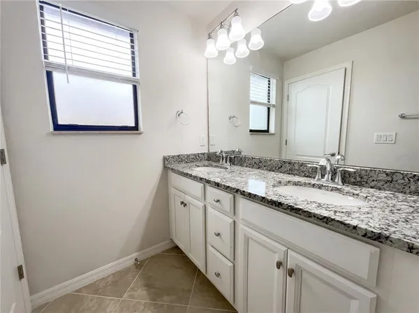 a bathroom with a granite countertop sink and a mirror