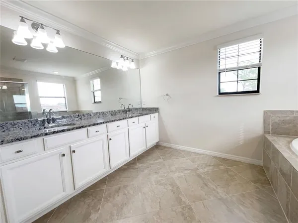 a bathroom with a granite countertop sink a large mirror and a window