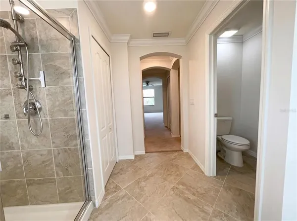 a spacious bathroom with a toilet and a shower