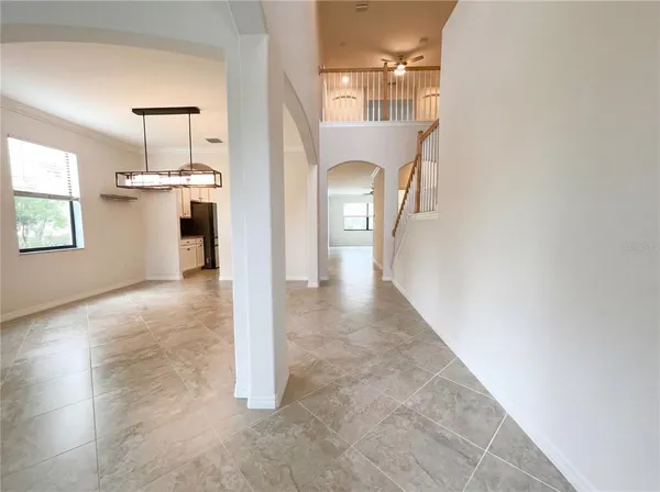 a view of a hallway with wooden floor and a living room