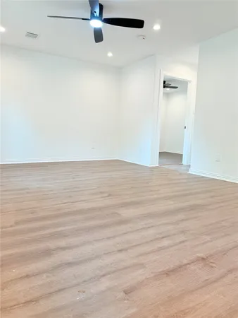 a view of an empty room with wooden floor