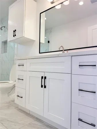 a bathroom with a sink a toilet and shower