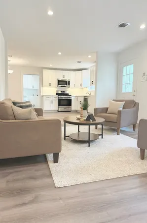 a living room with furniture and kitchen view