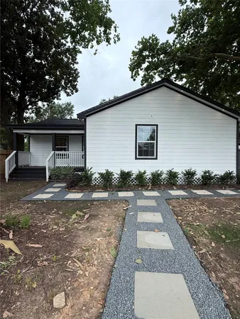 a backyard of a house with potted plants and large tree