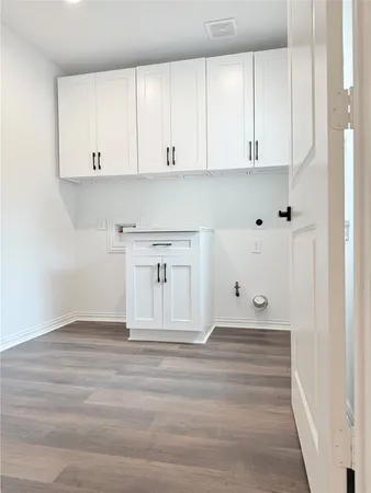 a view of kitchen with white cabinets and empty space