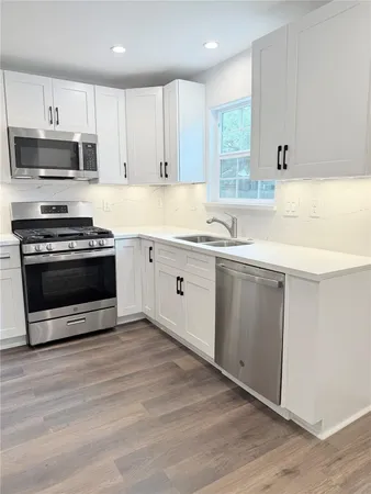 a kitchen with stainless steel appliances a stove microwave and sink