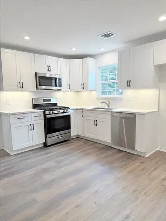 a large kitchen with cabinets and stainless steel appliances