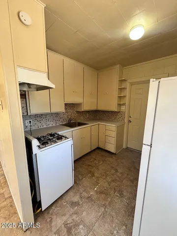 a kitchen with stainless steel appliances granite countertop a stove a sink and a refrigerator