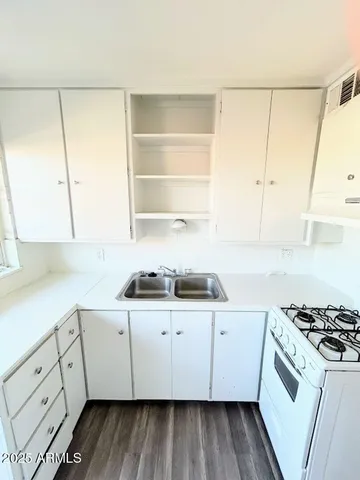 a kitchen with a sink a stove and cabinets