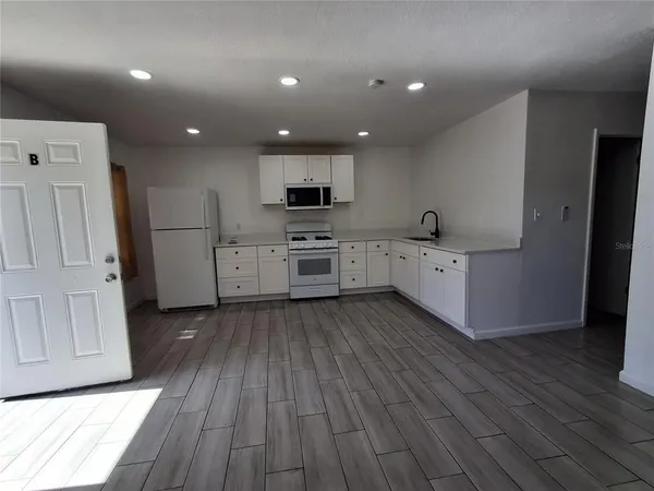 a kitchen with cabinets and wooden floor