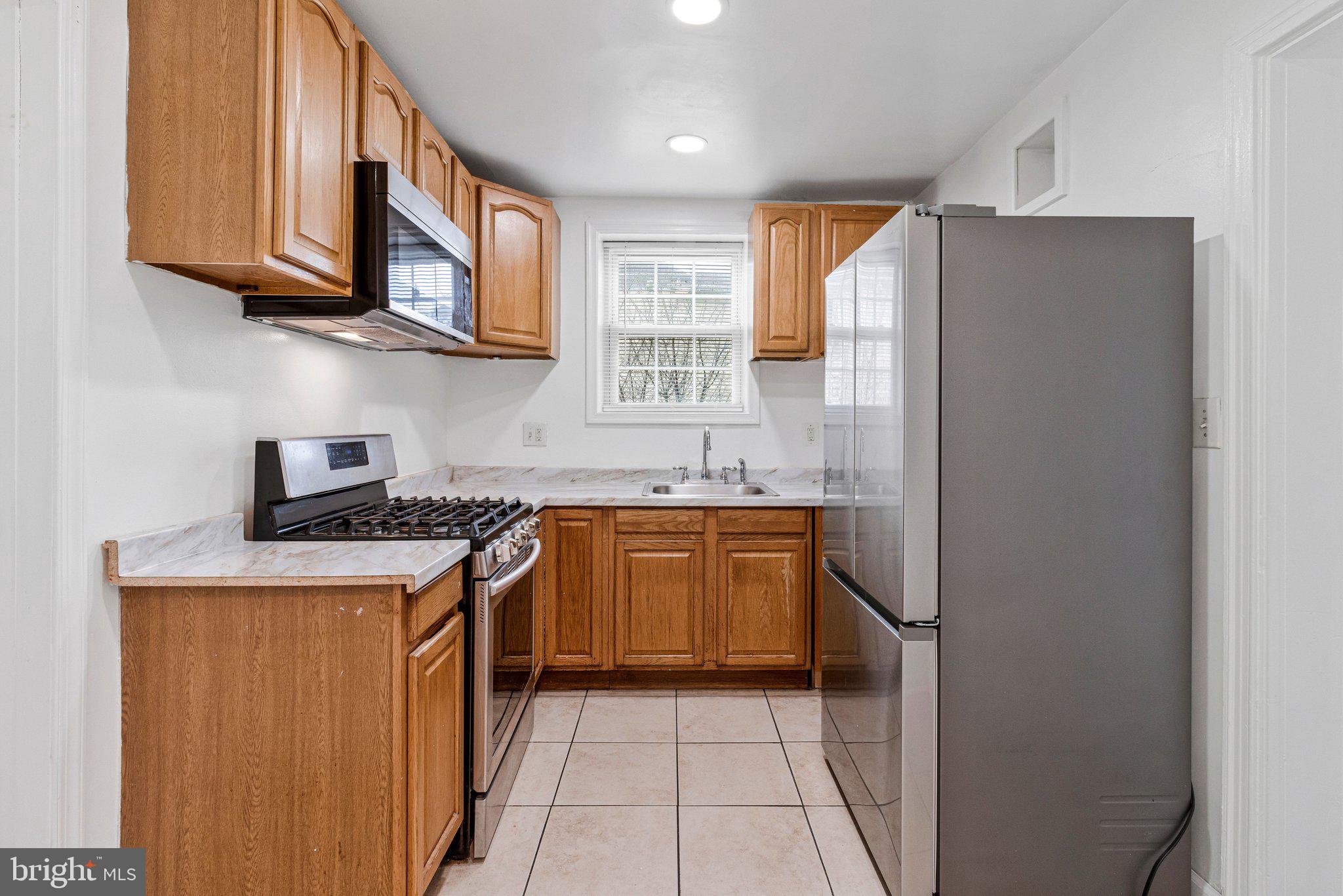 4834-4836 Sheriff Road Northeast Washington, DC 20019 - Photo 3 of 18 a kitchen with stainless steel appliances granite countertop a refrigerator and a sink