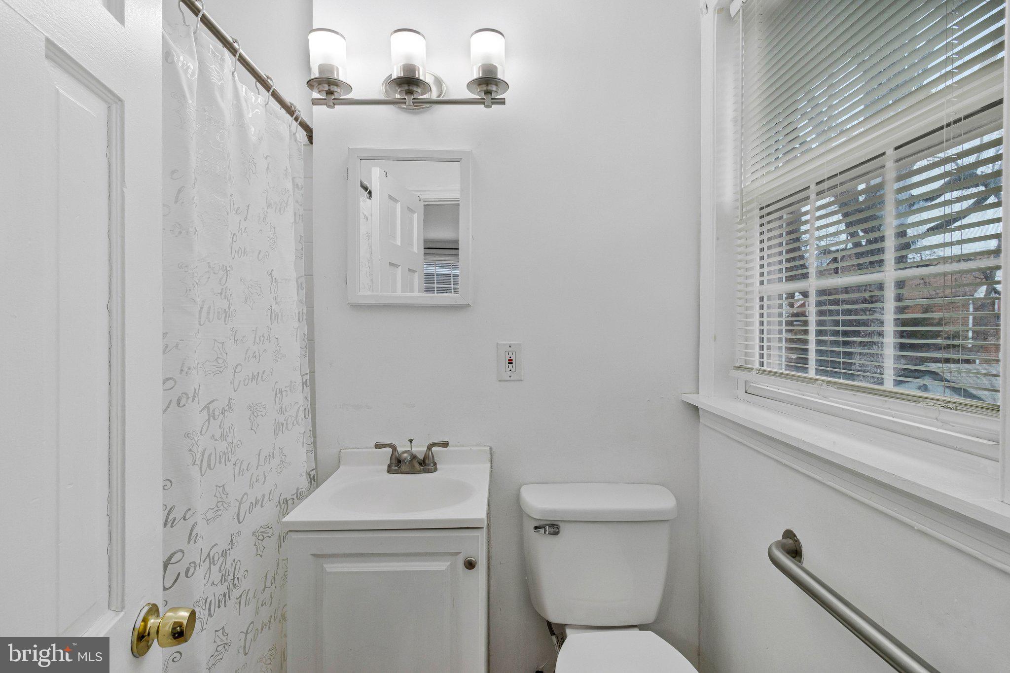 4834-4836 Sheriff Road Northeast Washington, DC 20019 - Photo 5 of 18 a bathroom with a toilet a sink and a window