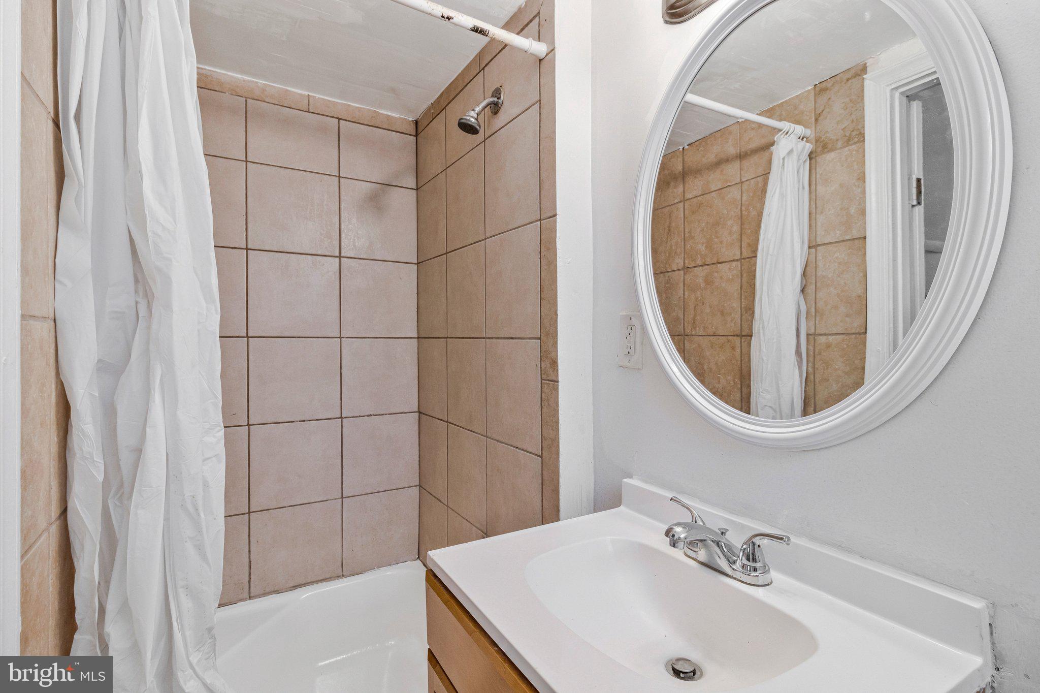 4834-4836 Sheriff Road Northeast Washington, DC 20019 - Photo 10 of 18 a bathroom with a sink and a mirror