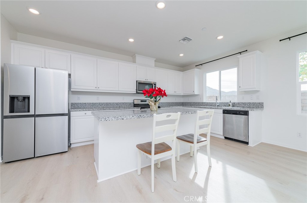 7309 Grazing Lane Riverside, CA 92507 - Photo 25 of 43 a kitchen with stainless steel appliances kitchen island granite countertop a refrigerator and a stove top oven