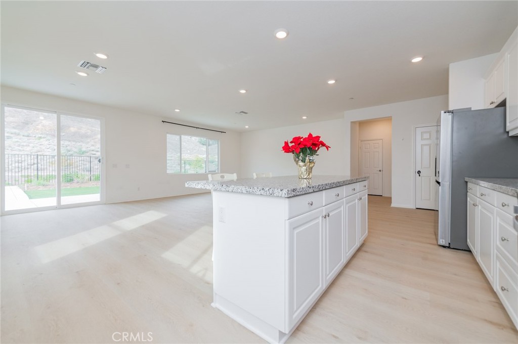 7309 Grazing Lane Riverside, CA 92507 - Photo 26 of 43 a kitchen with granite countertop a white refrigerator oven a sink dishwasher and a refrigerator with white cabinets