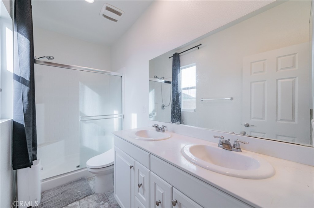 7309 Grazing Lane Riverside, CA 92507 - Photo 10 of 43 a bathroom with a sink a toilet and a large mirror