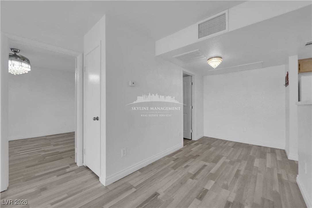 8070 West Russell Road, Unit 2063 Las Vegas, NV 89113 - Photo 12 of 31 Spare room with light wood-type flooring and a chandelier