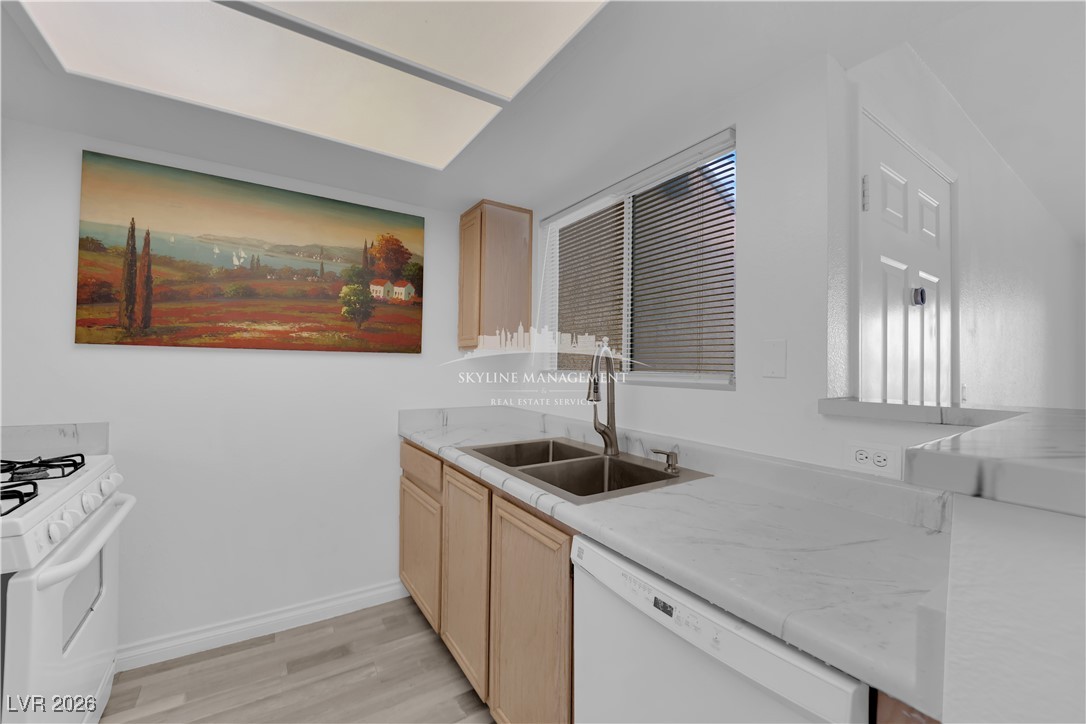 8070 West Russell Road, Unit 2063 Las Vegas, NV 89113 - Photo 14 of 31 Kitchen with light brown cabinets, white appliances, and light wood-style flooring
