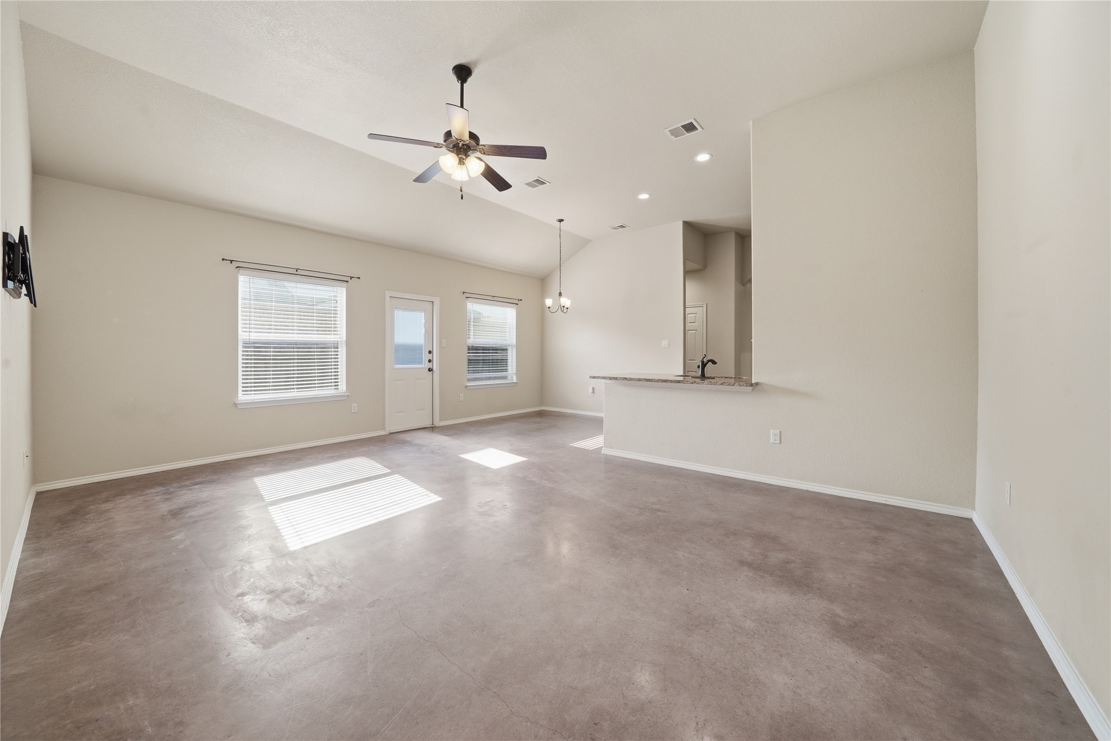 533 Jack Rabbit Lane, Unit A Buda, TX 78610 - Photo 10 of 34 A spacious common area with vaulted ceilings and ample natural light, perfect for gatherings.
