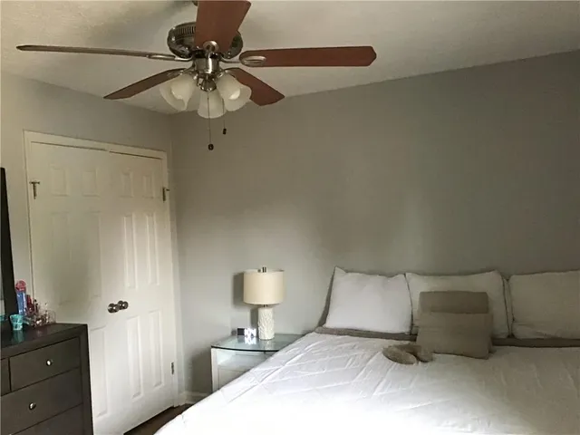 a bedroom with a bed and a lamp on the dresser