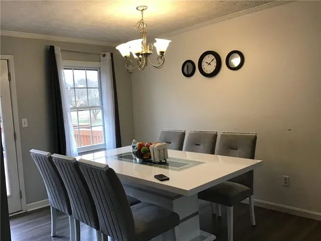 a view of a dining room with a table and chairs