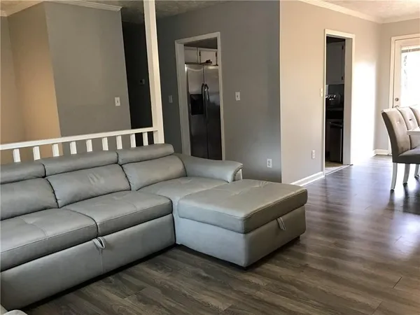 a living room with furniture and a wooden floor
