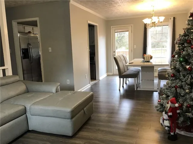 a living room with furniture wooden floor and a large window