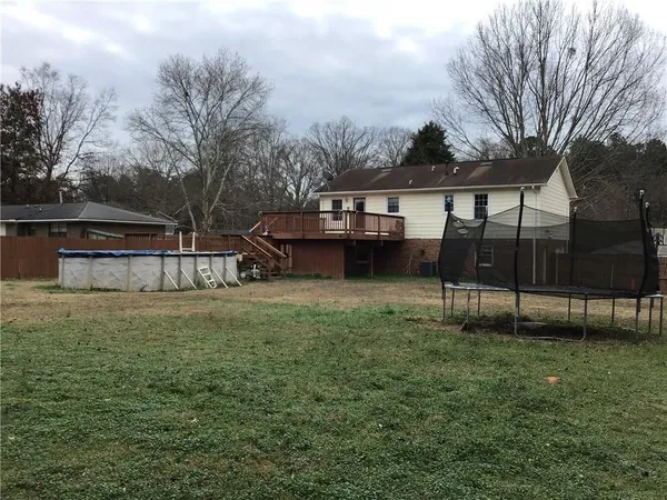 a view of a house with backyard and a tree