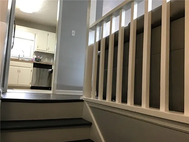 a view of staircase with open kitchen