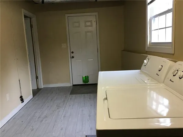 a utility room with wooden floor washer and dryer