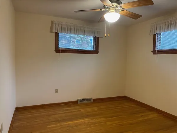 a view of an empty room with a chandelier fan