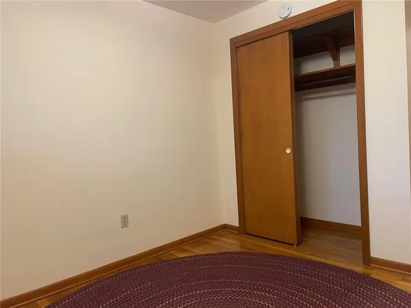 a view of empty room with wooden floor and closet