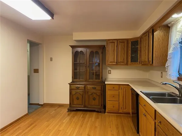a kitchen with a sink a wooden floor and cabinets