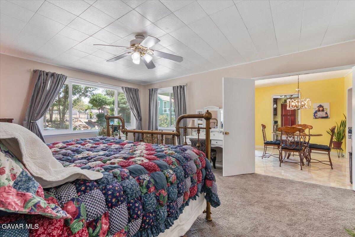 4817 Quartz Hill Road Quartz Hill, CA 93536 - Photo 23 of 41 a bedroom with a bed and a chandelier