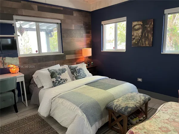 a bedroom with a bed and windows