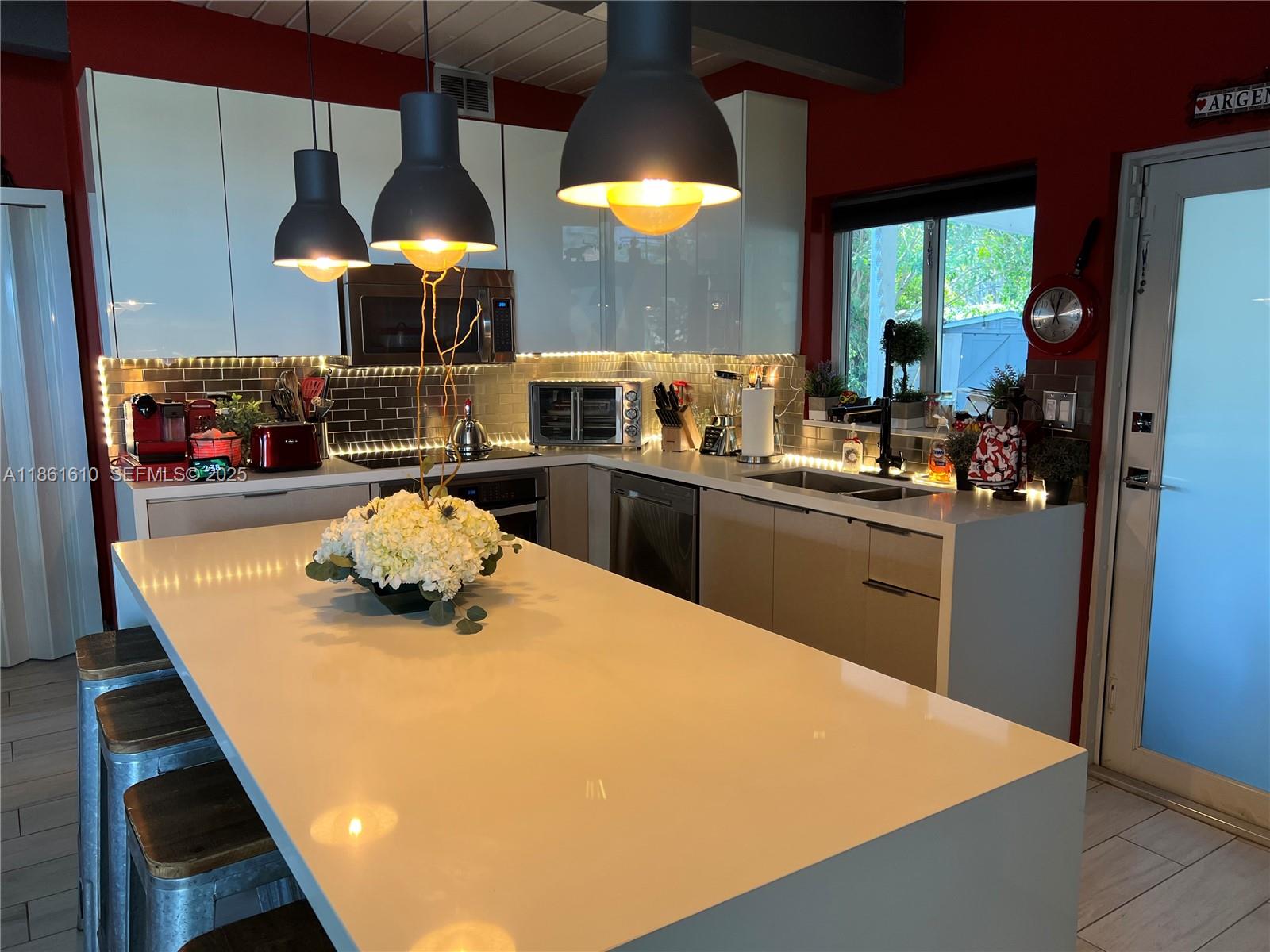 1900 Keystone Boulevard North Miami, FL 33181 - Photo 6 of 14 a kitchen with a stove a refrigerator and a dining table