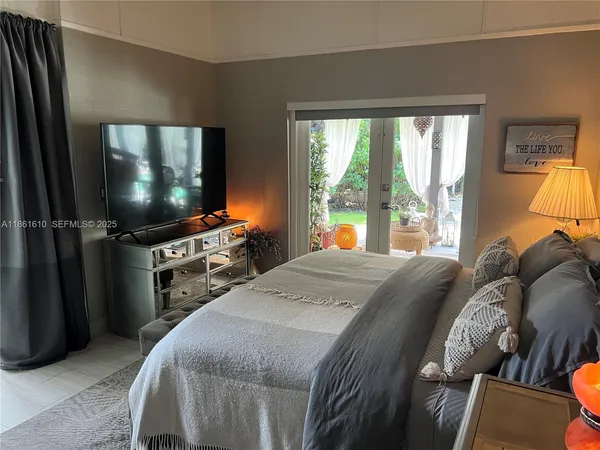 a bedroom with a bed and a flat screen tv