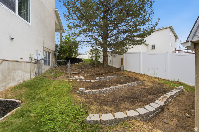 11882 Pond Ridge Drive Draper, UT 84020 - Photo 49 of 49 Expansive backyard with a mature tree, terraced garden beds, and white privacy fencing