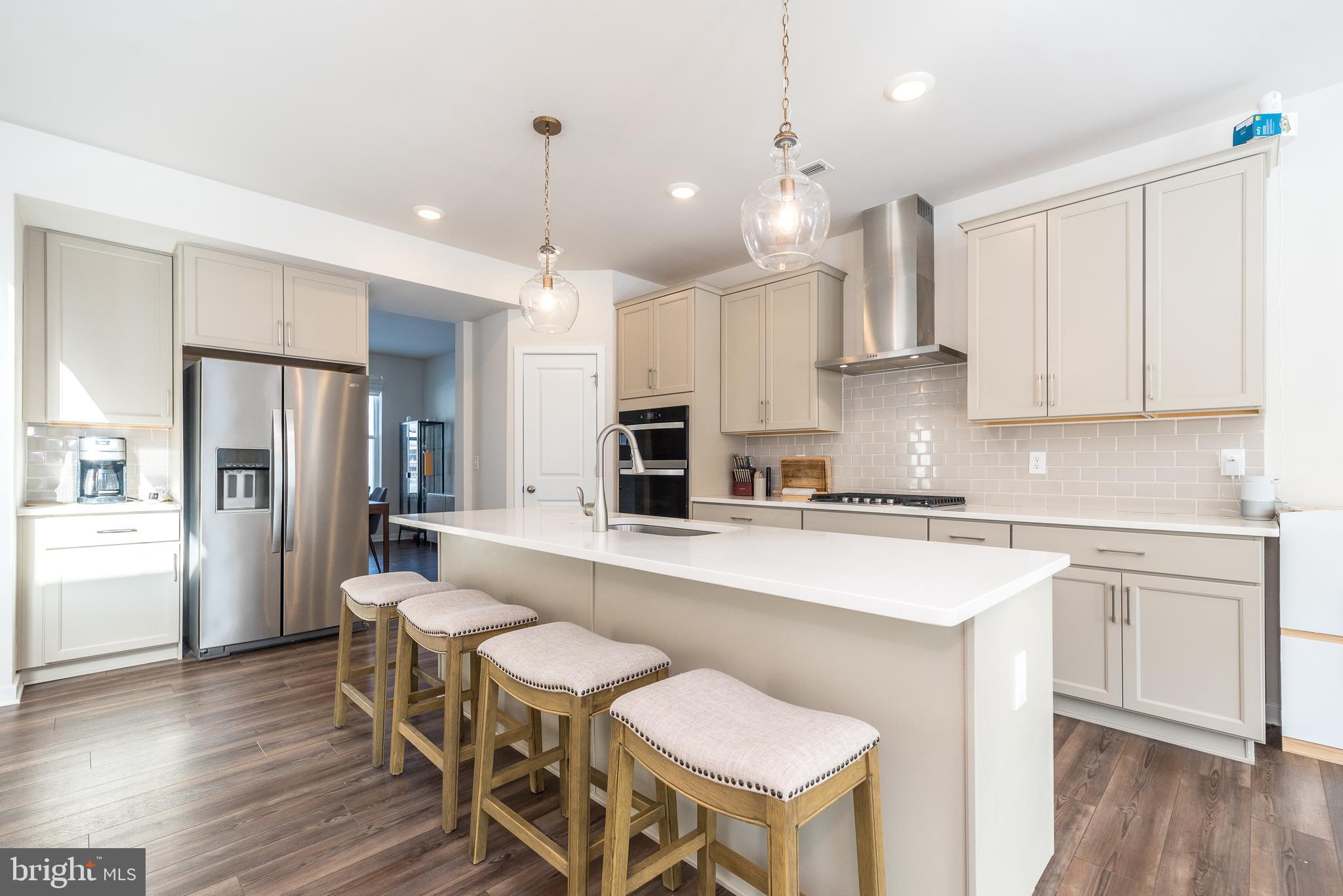 1033 Mariwill Drive Quakertown, PA 18951 - Photo 23 of 67 a large kitchen with cabinets wooden floor white stainless steel appliances and dining table