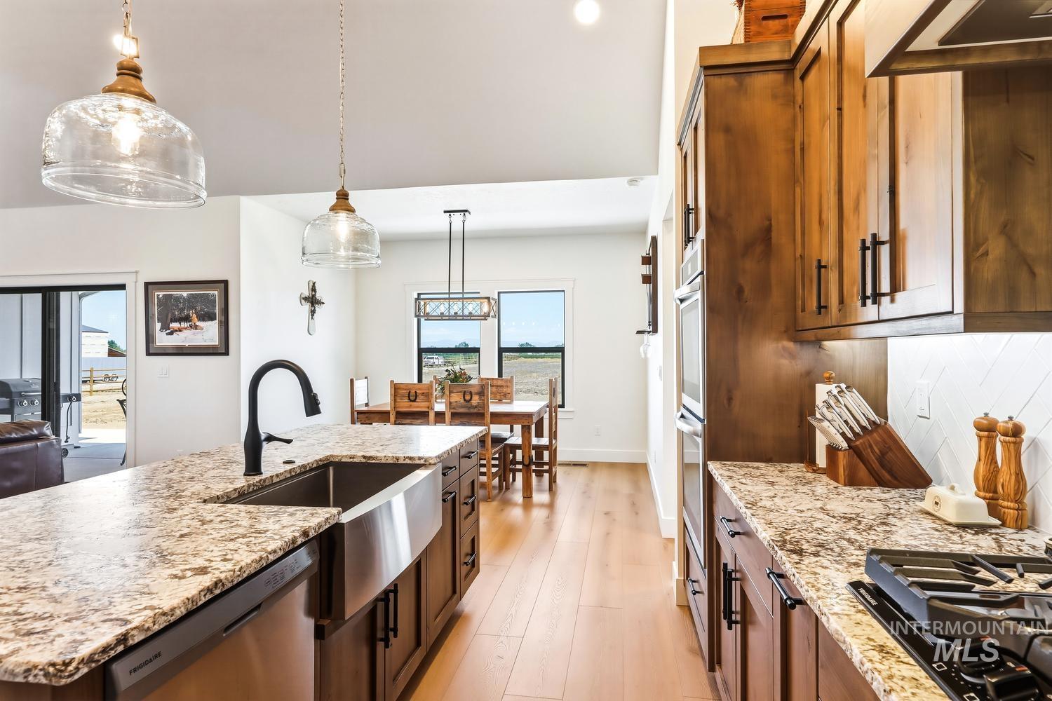 18658 Tranquil Place Caldwell, ID 83607 - Photo 15 of 44 Kitchen island with a farmhouse sink and black faucet