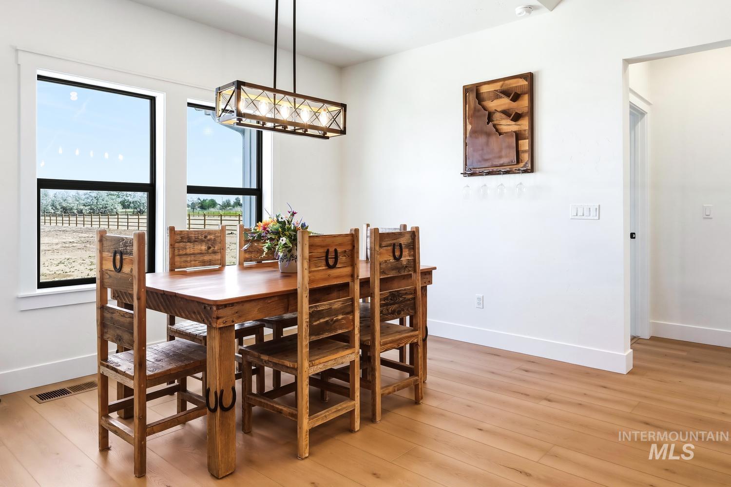 18658 Tranquil Place Caldwell, ID 83607 - Photo 16 of 44 Dining area with wood-finish flooring, white walls, and prominent black-framed windows