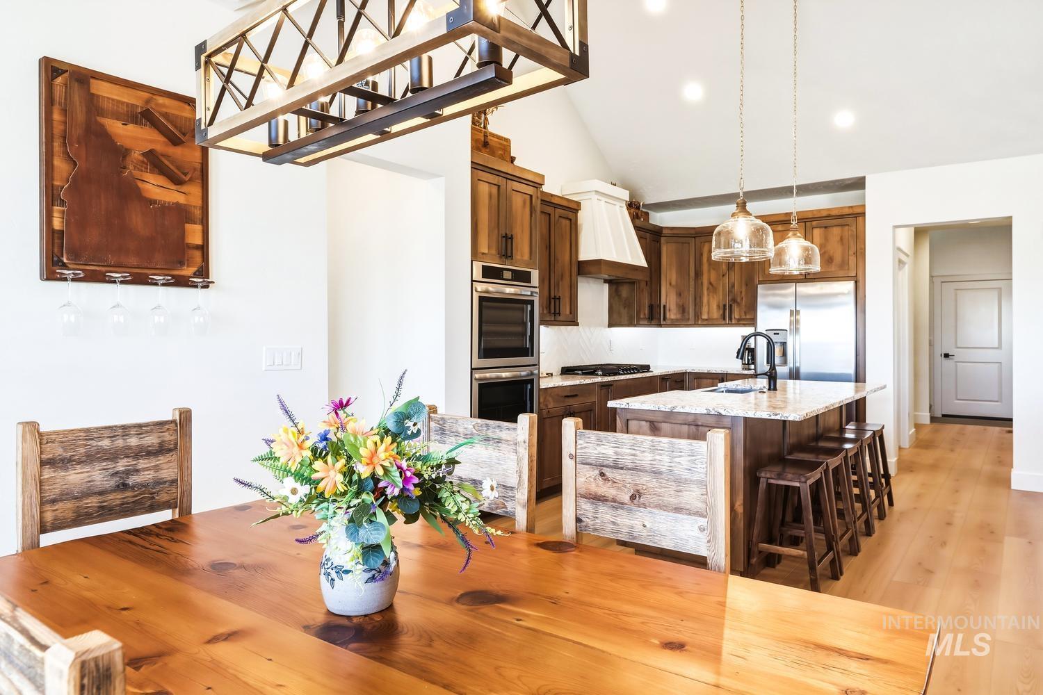 18658 Tranquil Place Caldwell, ID 83607 - Photo 17 of 44 Open-concept kitchen and dining area featuring a vaulted ceiling and wood-finish flooring