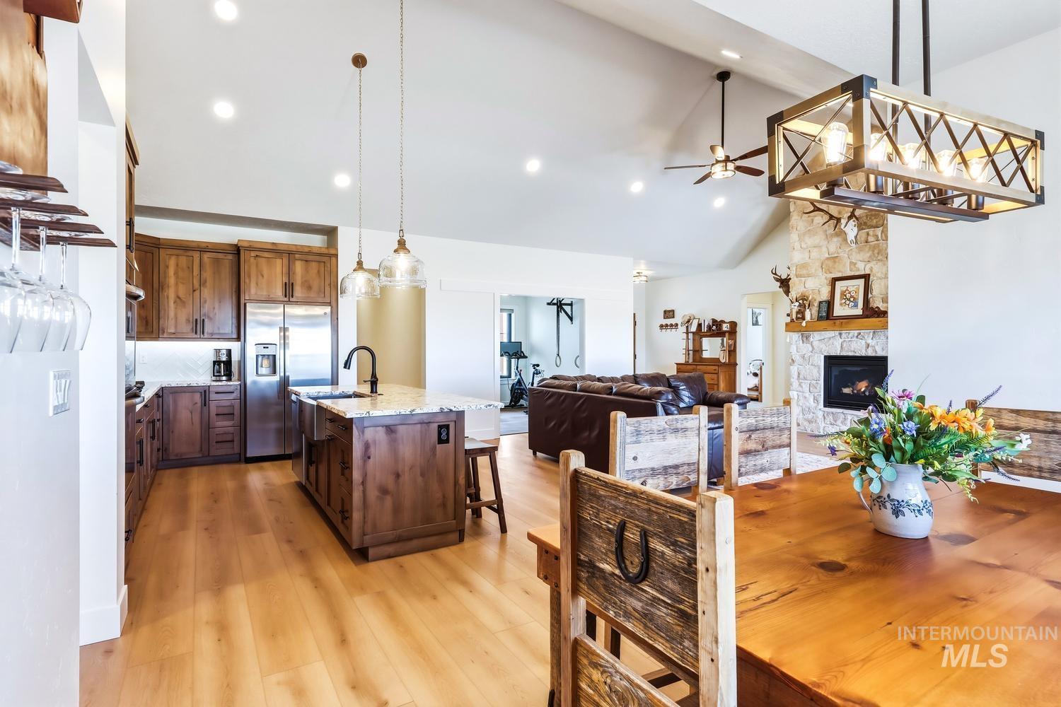 18658 Tranquil Place Caldwell, ID 83607 - Photo 18 of 44 Vaulted ceilings with recessed lighting over a kitchen featuring wood cabinetry, stainless steel appliances, and an island with a farmhouse sink