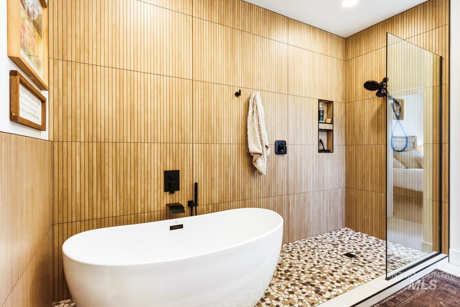 18658 Tranquil Place Caldwell, ID 83607 - Photo 25 of 44 Freestanding soaking tub complemented by fluted wood-finish wall paneling