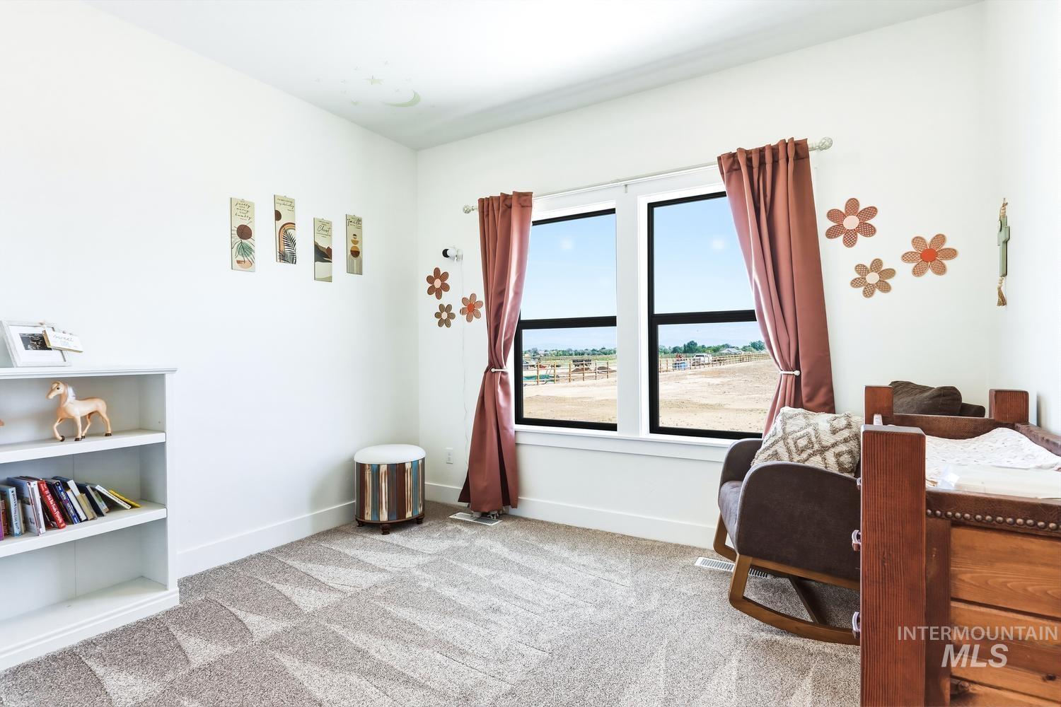 18658 Tranquil Place Caldwell, ID 83607 - Photo 31 of 44 Bright room featuring light gray patterned carpeting, white baseboards, and a large window with black frames