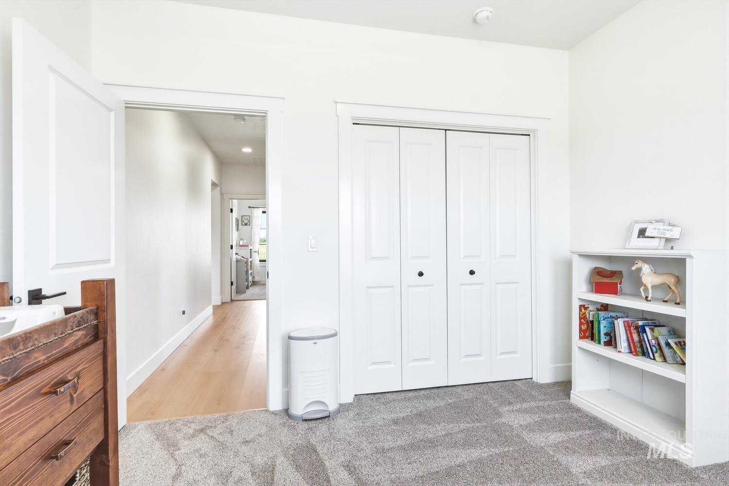 18658 Tranquil Place Caldwell, ID 83607 - Photo 32 of 44 Plush patterned carpeting, a hallway with wood-finish flooring, and crisp white walls