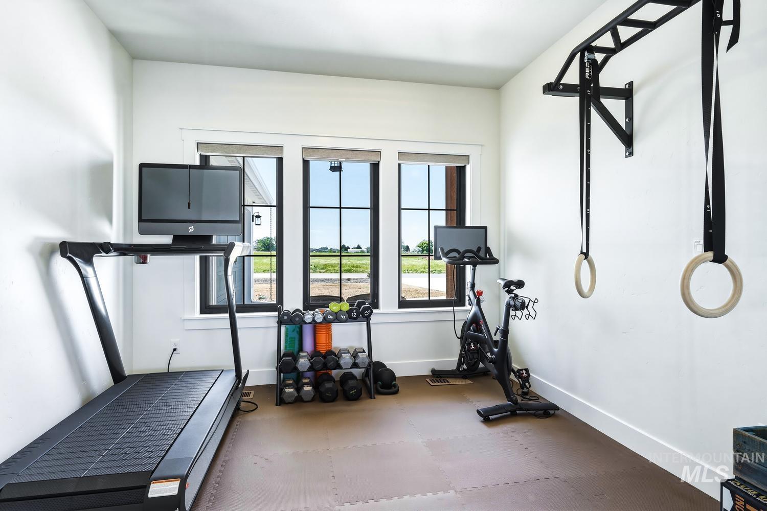 18658 Tranquil Place Caldwell, ID 83607 - Photo 33 of 44 Dedicated exercise room featuring large windows, white walls, dark trim, and a durable floor mat system