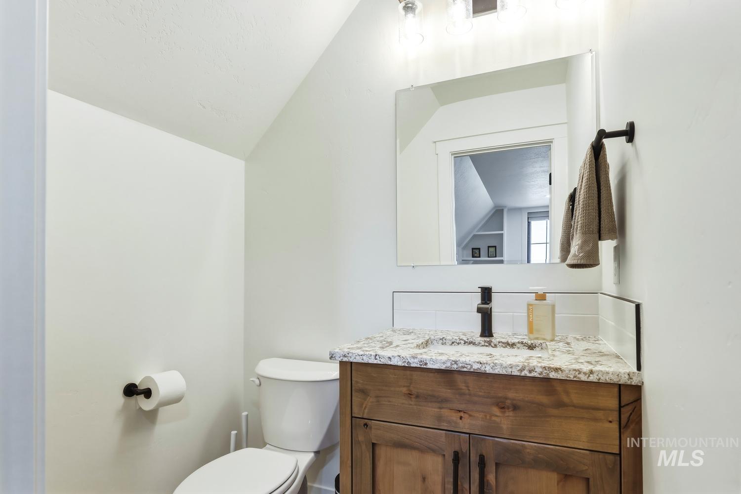 18658 Tranquil Place Caldwell, ID 83607 - Photo 37 of 44 Bathroom featuring a wood-finish vanity with a light-toned countertop, a rectangular undermount sink, and a matte black faucet